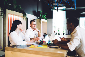 Multiracial team of creative millennials working on project