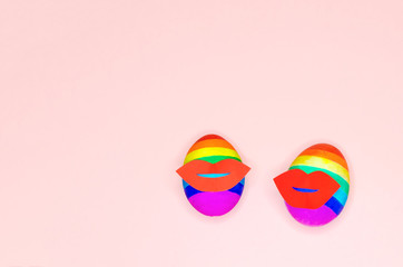 Two eggs in rainbow colors with red female lips on pink background. flag LGBT, LGBTQ. easter, valentines day for gays and lesbians, gay pride, party, homosexual marriage,  married couple. copy space