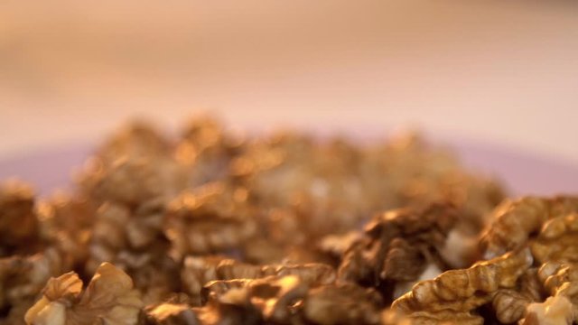 Woman collects peeled Walnuts in hand  and drops it into the plate