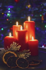 Świąteczne zapalone świece na tle choinki i dekoracji świątecznych.
