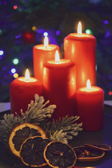 Świąteczne zapalone świece na tle choinki i dekoracji świątecznych.
