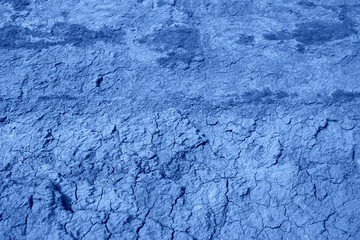 The surface of the cracked dried clay background. Color of the year 2020 classic blue.   Blue and...