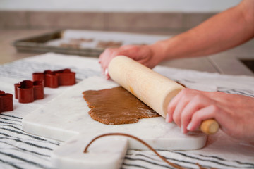 Woman rolling out gingerbread dough at home for Christmas