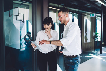 Concentrated partners surfing tablet at workplace