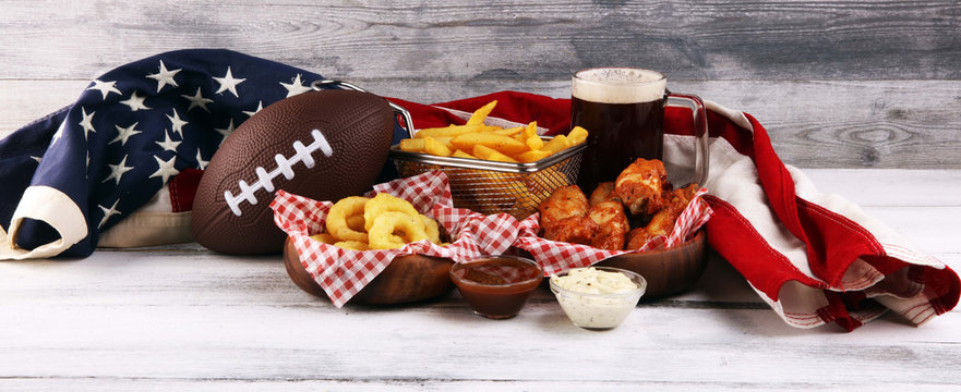 chicken wings, fries and onion rings for football on a table. Great for Bowl Game party
