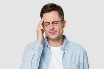 Close up head shot of young man having headache migraine