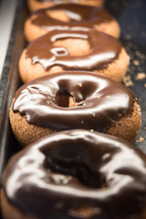 delicious chocolate glazed doughnuts in bakery display