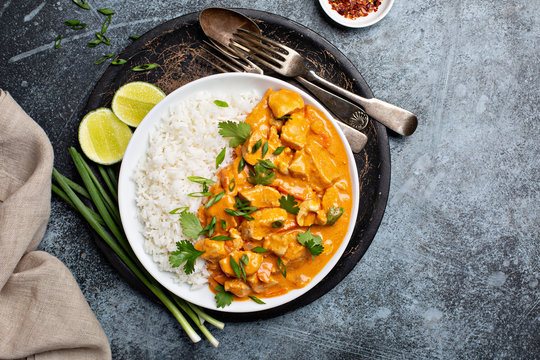 Chicken and cashew red curry with rice and herbs, thai inspired dish overhead view