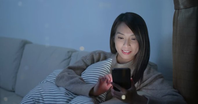 Woman use of smart phone at home with window glass reflection