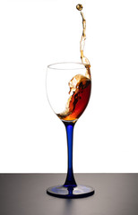 Splash of drink in glass on white background