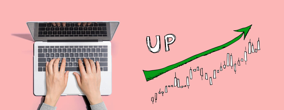 Market up trend chart with person using a laptop computer