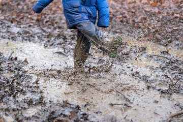 Young children playing in a muddy puddle