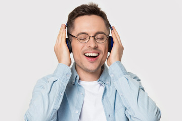 Overjoyed happy guy in eyeglasses enjoying favorite music.