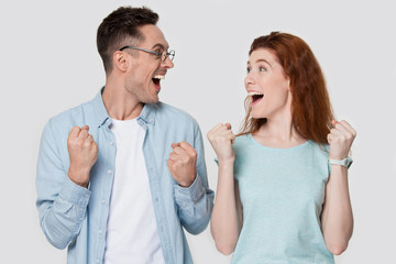 Overjoyed happy attractive young family couple celebrating goal achievement.