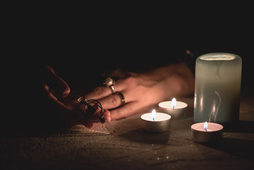 Fortune teller holding in hands a magic pendulum close up.