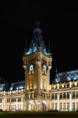 Fototapeta premium Clock tower of the Palace of Culture in Iasi, Romania. Evening illumination of the palace, cityscape. The building combines several architectural styles: neo-Gothic, romantic and neo-baroque.