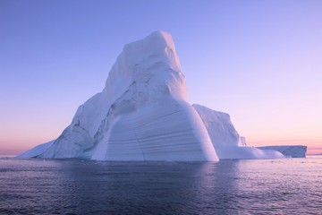 Iceberg drifting away in the icy waters of Disco Bay in front of Greenland
