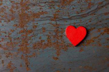 Red wooden heart on a metal background with copy space