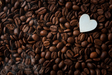 Coffee beans with white hearts, with smoke and copy space