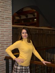 Woman leaning on a railing next to brick column