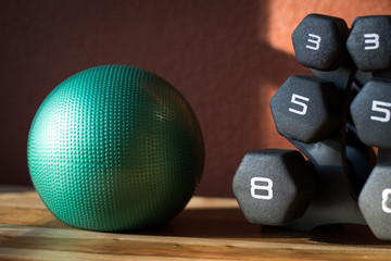 Medicine ball beside a stack of dumbbell weights