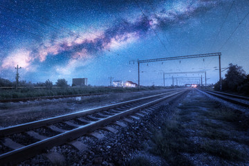 Milky Way over the railway station at starry night. Beautiful industrial landscape with blue sky...