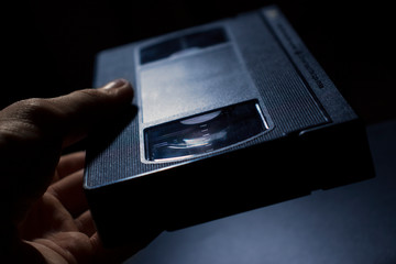 video cassette in hand on a black background
