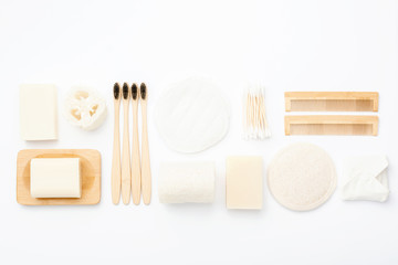 Zero waste with natural biodegradable self care products on blue. Bamboo toothbrushes, handmade soap shampoo bars, cotton buds pads, hygiene products luffa on white, top view, selective focus
