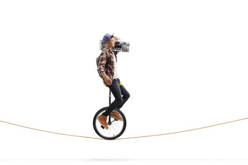 Male teenager riding a unicycle and carrying a boombox radio © Ljupco Smokovski