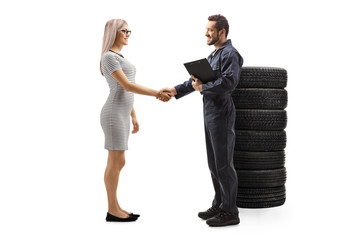 Auto mechanic shaking hands with a young female customer