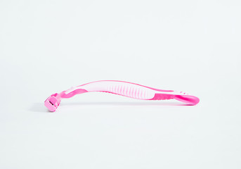 A pink women's razor on a bright white background. Shaving legs, woman body concept.