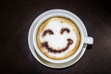 the cup of coffee with smile on the table.  Smile. Be happy with coffe