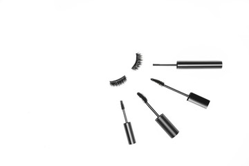 Basic product for eye makeup. Types mascara in black tube, long fake magnetic hairs lashes on white backdrop. Beauty blog concept, minimalistic idea. Eyelash extension. Copy space