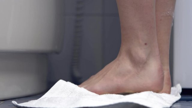 Close view of wet feet stading on towel after bathing, in bathroom.