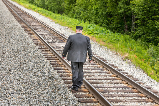 Walk the line - train conducter walking on a railroad track
