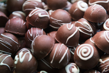 Close up of luxury pile of chocolate candies. Assorted chocolate candies. Dark chocolate candy balls for anniversary or wedding party. Delicious, tasty, diet, festive concept. Selective focus.
