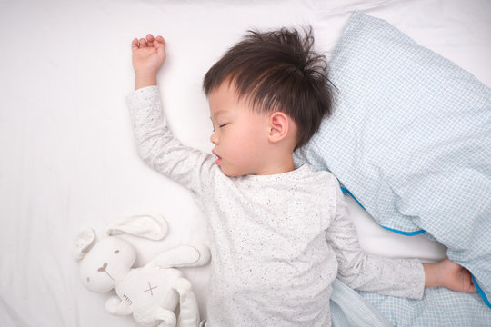 Cute Little Asian 3 - 4 Years Old Toddler Boy Kid In Pajama Sleeping / Taking A Nap On White Bed Sheet In Bed , Bedtime For Kids Concept With Copy Space