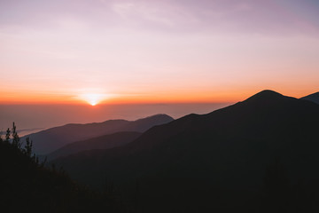 Magnifique levé de soleil orange et rouge depuis les montagnes