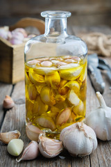 Garlic aromatic flavored oil or infusion bottle and garlic cloves.