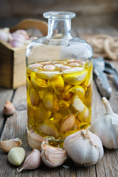 Garlic aromatic flavored oil or infusion bottle and garlic cloves.