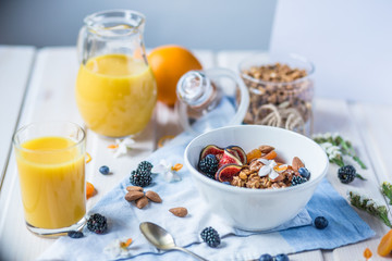 Healthy breakfast with oatmeal porridge with fresh blackberry, figs fruits and nuts. Juice and oranges