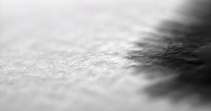 Ink reveal as black ink runs and bleeds on white paper