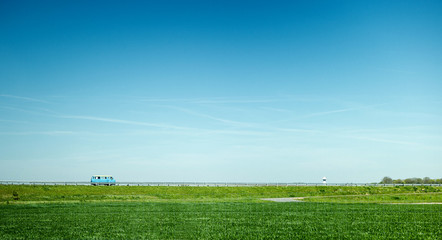 Blue RV camper van driving fast on highway with destination holidays