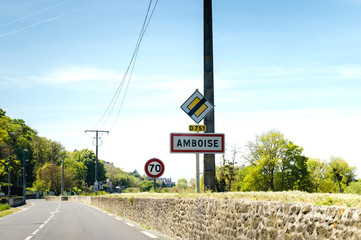 Driver point of view at the entrance to Amboise, French street sign with 70 kmh speed limit sign