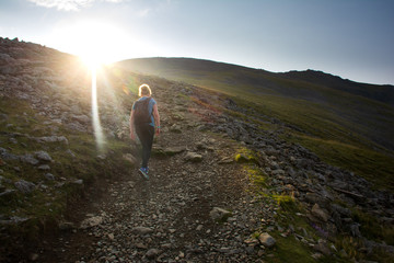 Young woman walking up mountain - 307751008