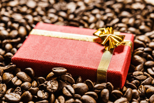 Red gift box on roasted coffee beans.