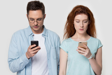 Concentrated young family couple using mobile phones.