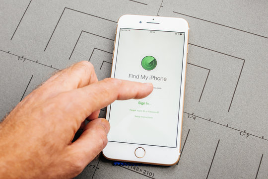 PARIS, FRANCE - SEP 26, 2016: Male Hand Holding New Apple IPhone 7 8 Plus After Unboxing And Testing By Installing The App Application Software Find My Iphone