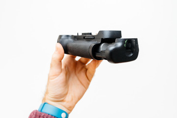 Photographer hand holding against white background a battery camera grip for his new camera