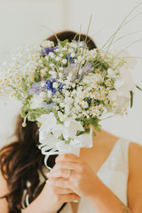 La mariée derrière son bouquet